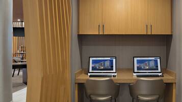 A modern office space with two desks, each with a laptop and a chair.