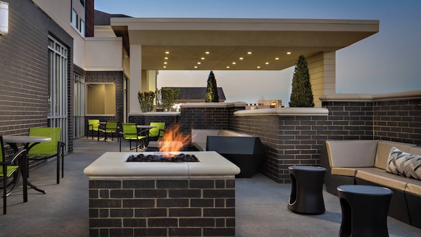 An outdoor patio with a fire feature, seating, and a covered area. - SpringHill Suites Oklahoma City Midwest City/Del City (Del City)