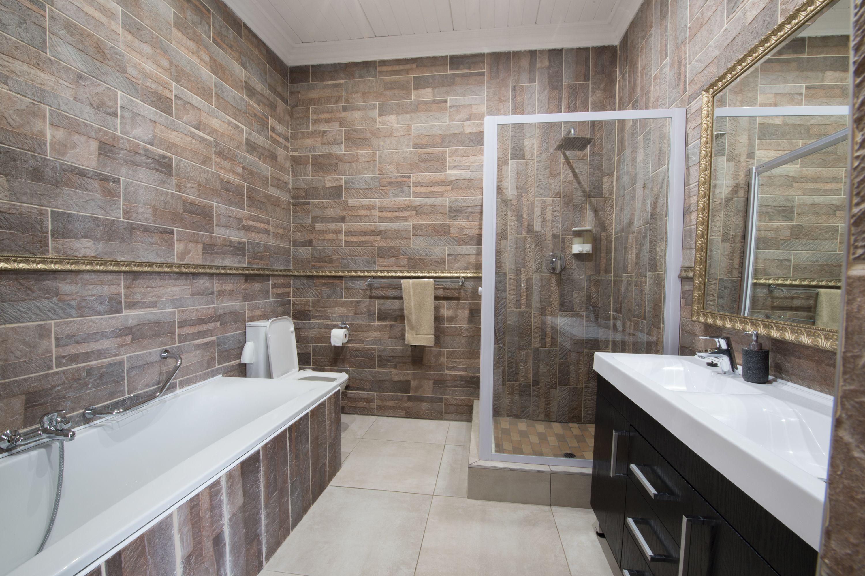 Ein modernes Badezimmer mit Badewanne, Dusche und Waschtisch.