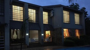 Una casa de dos pisos con piscina, ventanas amplias y un porche cubierto.