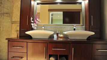 A bathroom with a double sink vanity, a large mirror, and a towel rack.