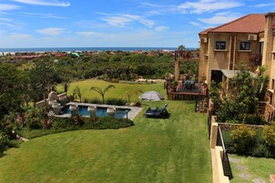 Una piscina al aire libre, sombrillas, tumbonas