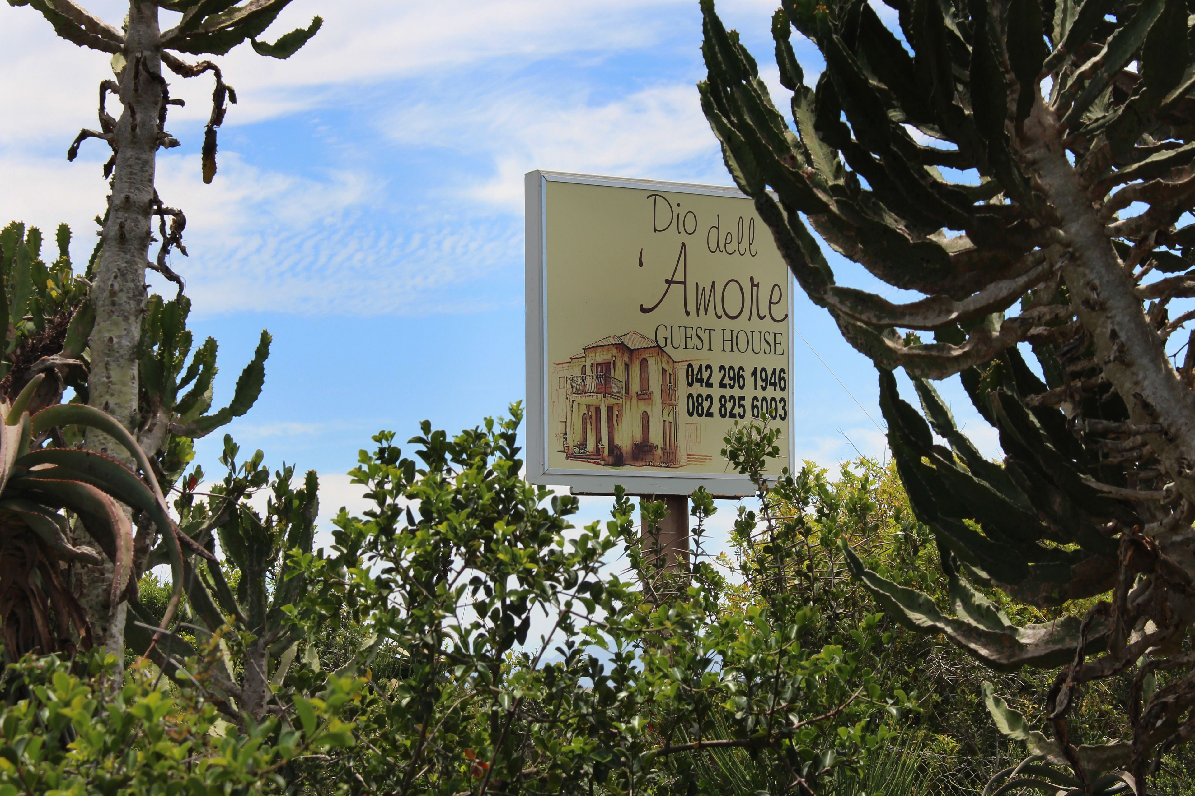 A sign for 'Dio dell Amore Guest House' with contact numbers.