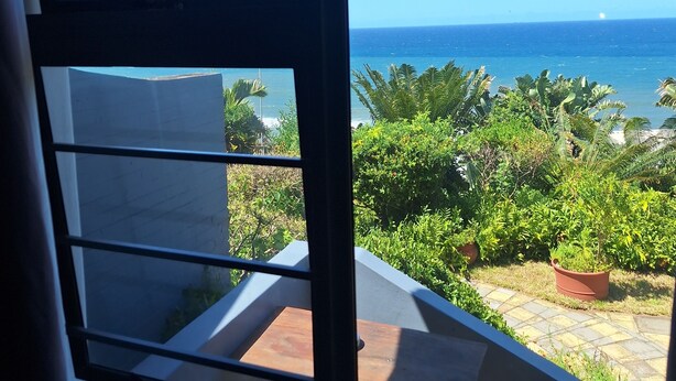 Vista desde un balcón con cielo azul y mar.