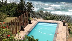 Piscina rectangular con revestimiento azul, rodeada por un deck de baldosas.