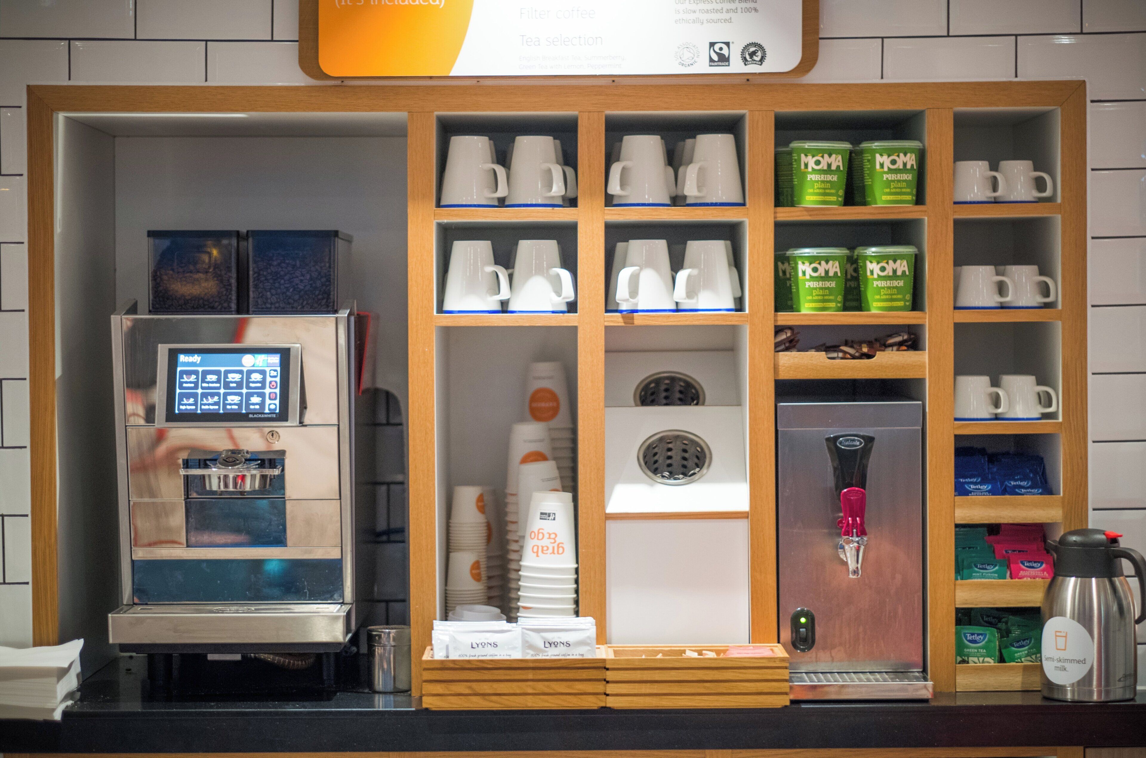 A coffee station with a coffee machine, tea selection, and various tea bags.