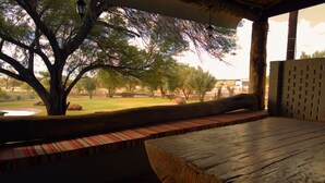 Un banc en bois offrant une vue sur un parc, avec des arbres et une pelouse.