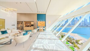 Un intérieur moderne comprenant une cuisine, un coin repas et une grande fenêtre offrant une vue sur la ville et le port.