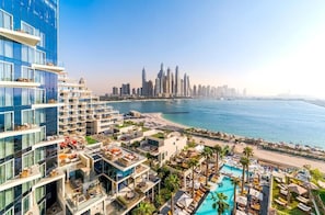 Un hôtel de grande hauteur doté de nombreux balcons offrant une vue sur une plage et sur le panorama urbain.