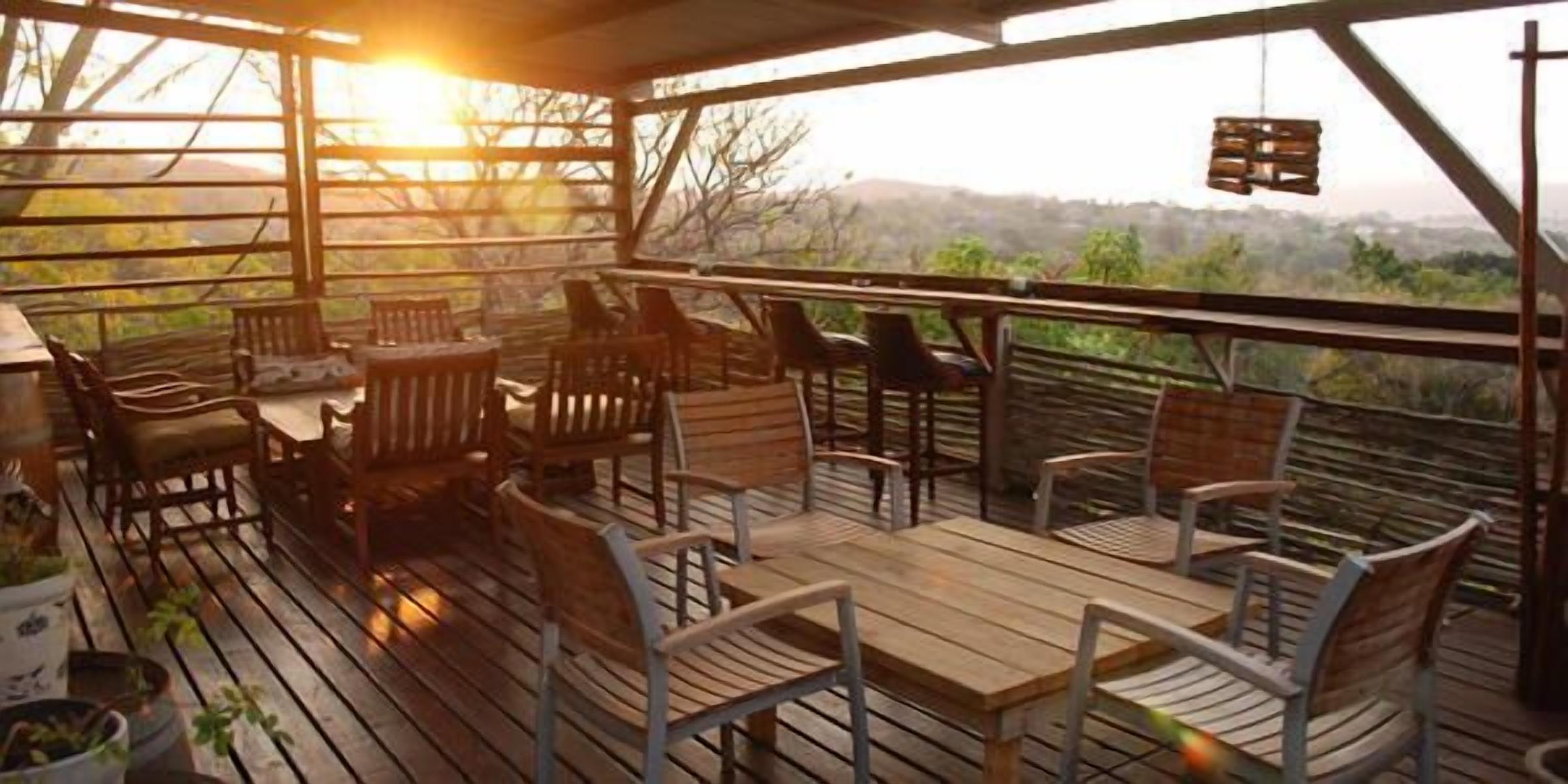 An outdoor deck with wooden furniture and a view of the landscape.