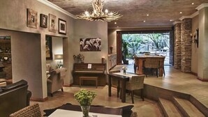 Un amplio salón con chimenea, asientos y vistas al exterior.