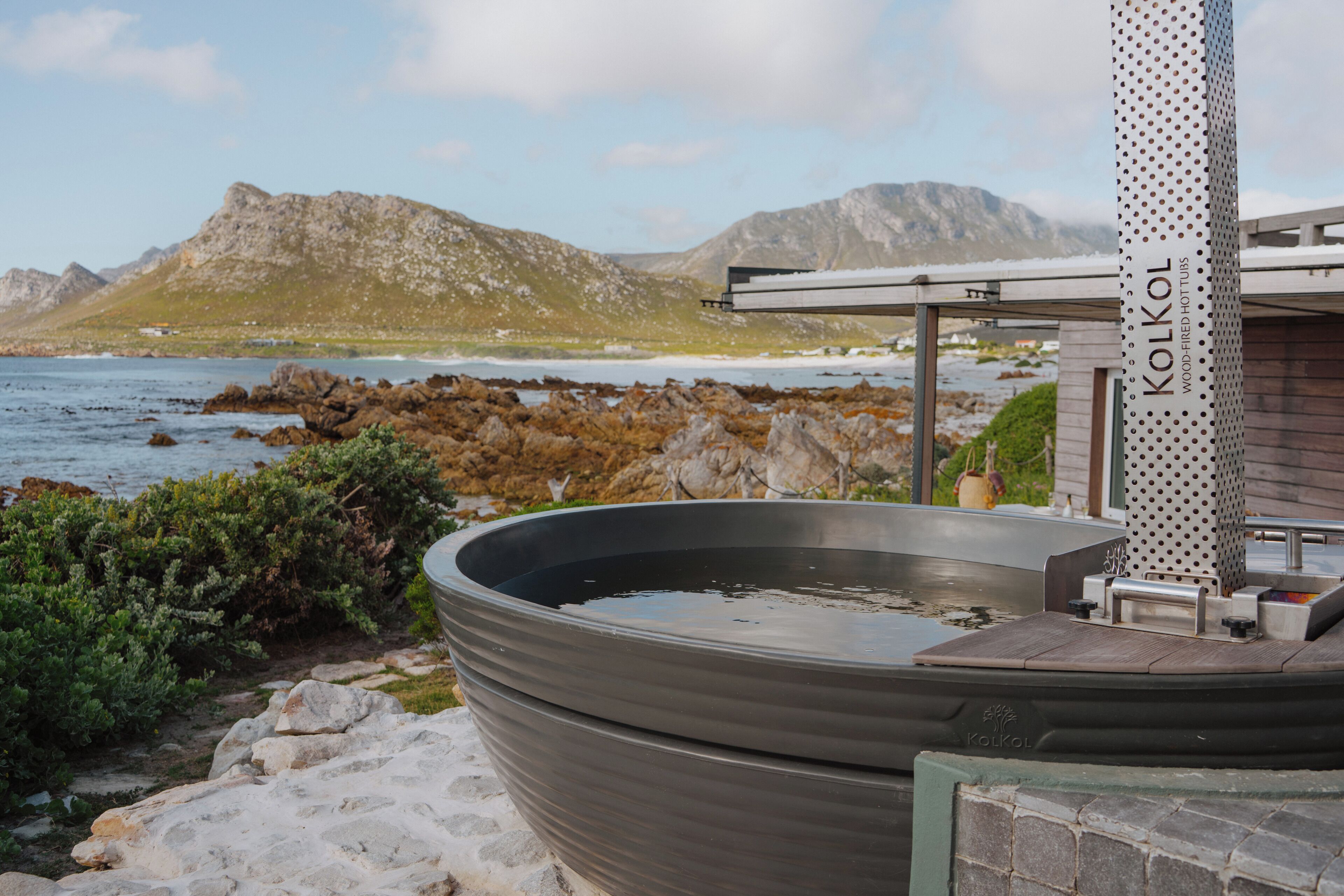 A hot tub with a view of the sea and mountains.