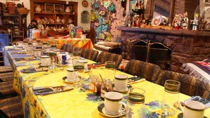 A dining area with a long table set for a meal, surrounded by chairs. - Inn at Halona (Zuni)