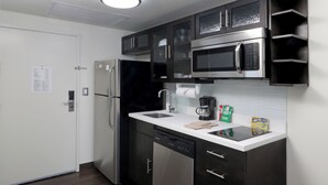 A modern kitchen with stainless steel appliances, a dishwasher, and a coffee maker.