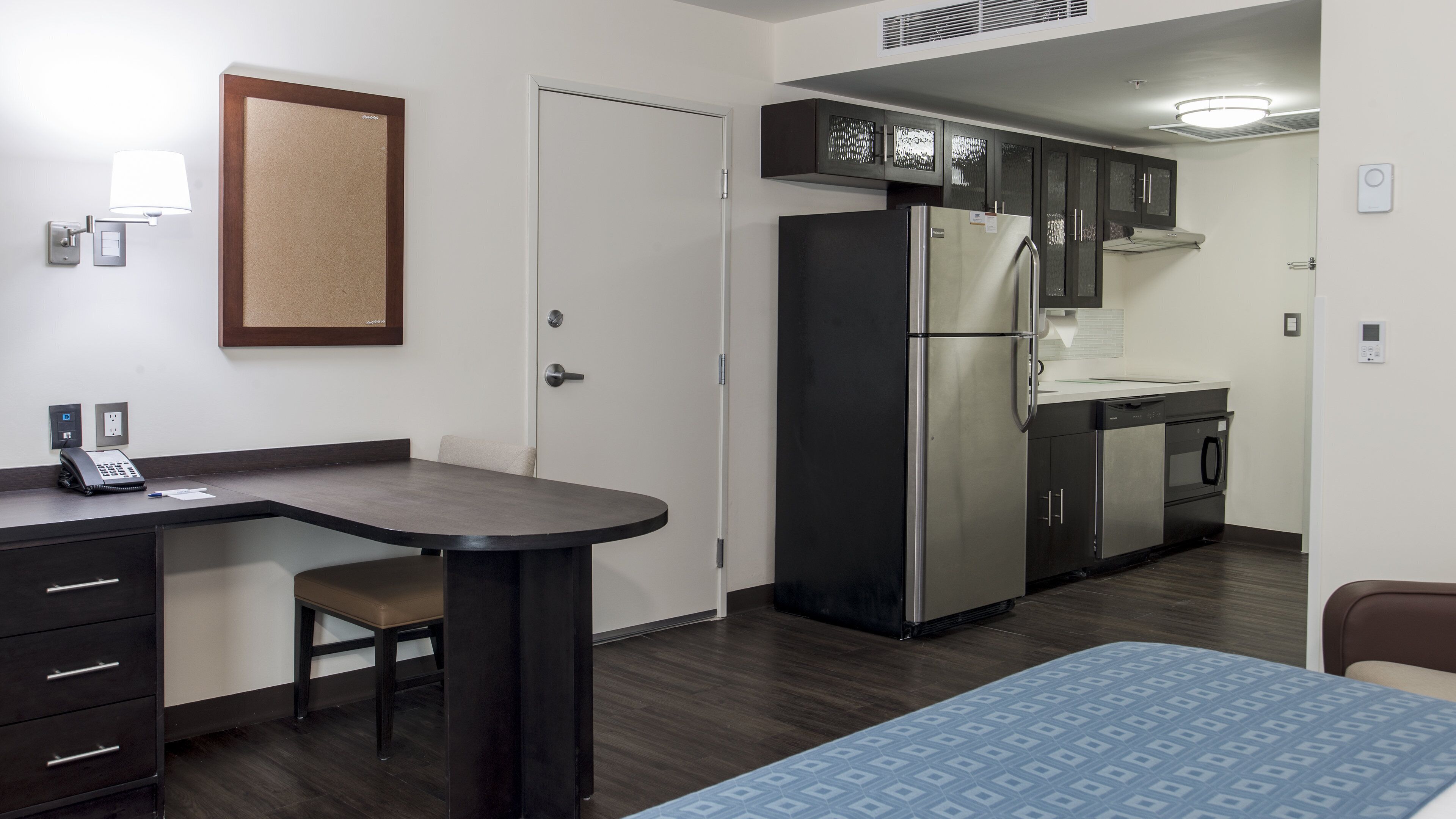 A compact kitchen with a refrigerator, oven, and a small dining area with a table and chair.