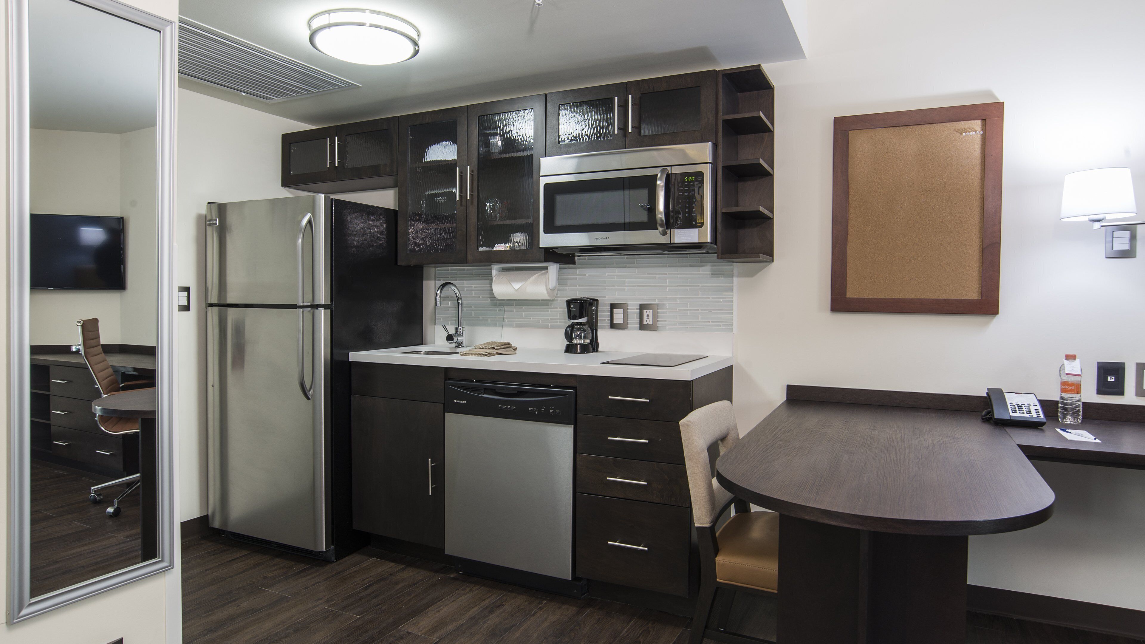 A modern kitchen with stainless steel appliances, a built-in microwave, and a coffee maker.
