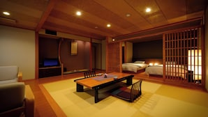 A traditional Japanese-style room with tatami flooring, a low table, and a TV on a cabinet. - Wakamatsuya (Yamagata)