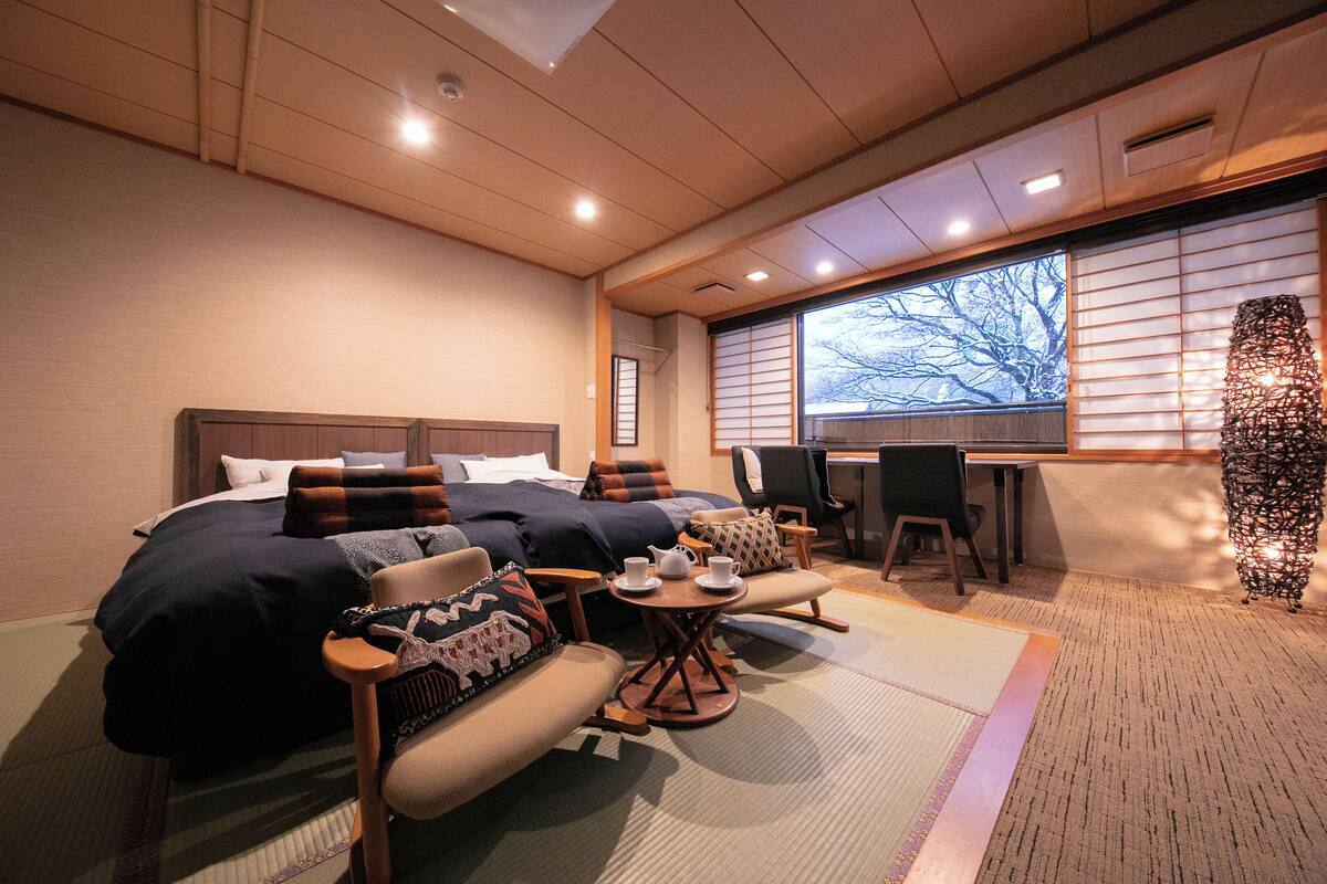 Ein modernes Hotelzimmer mit einem großen Bett, einem Schreibtisch, einem Sessel und einer Couch.