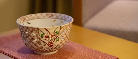Un bol orné de motifs floraux, posé sur une table recouverte d’une nappe rose.