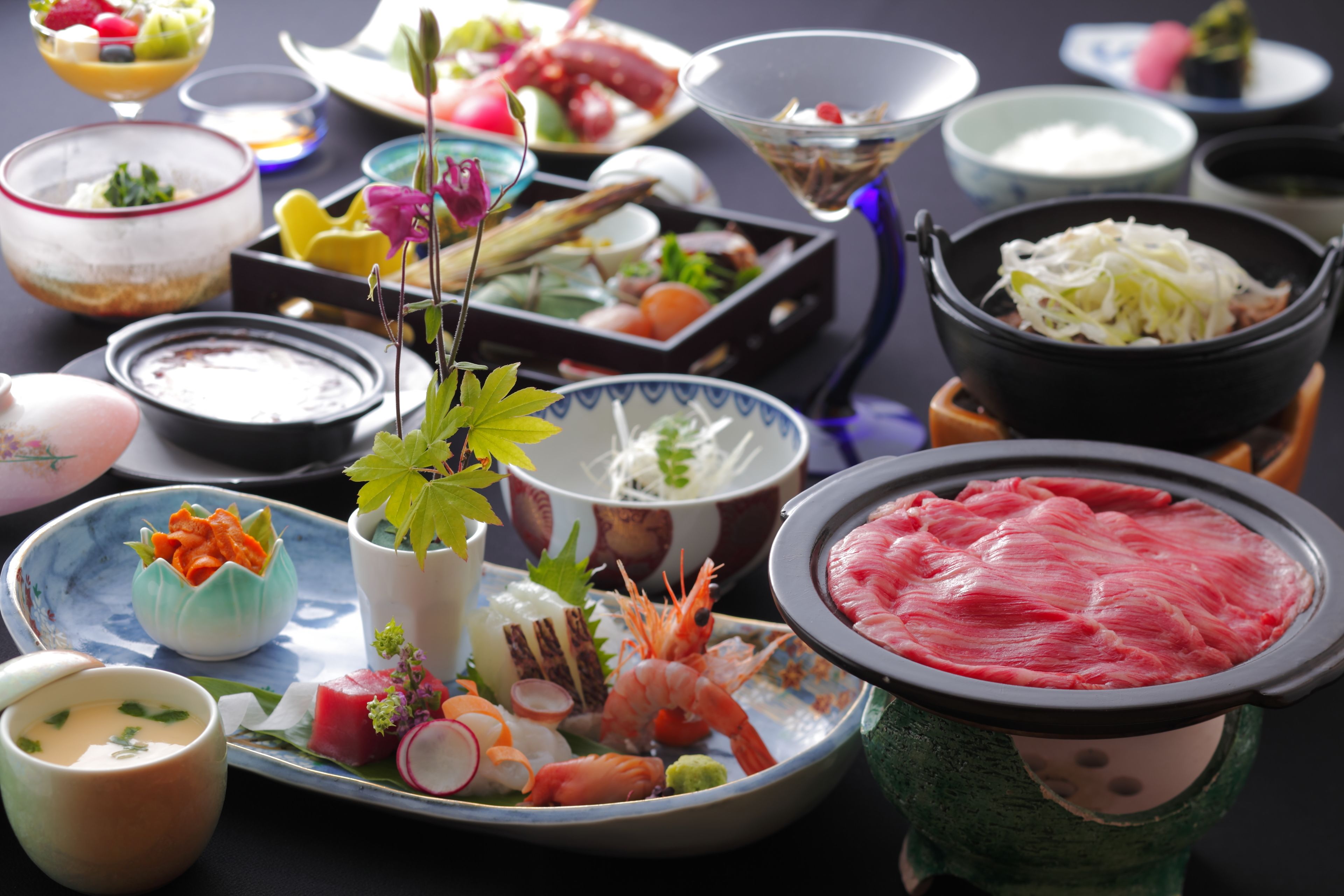 A variety of dishes and food items on a table, including seafood, vegetables, and other delicacies, suggesting a dining experience.