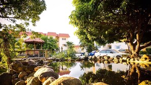 A tranquil outdoor setting with a pond, rocks, and a gazebo. - Kingston Guest Apt at Plantation Springs (Kingston)