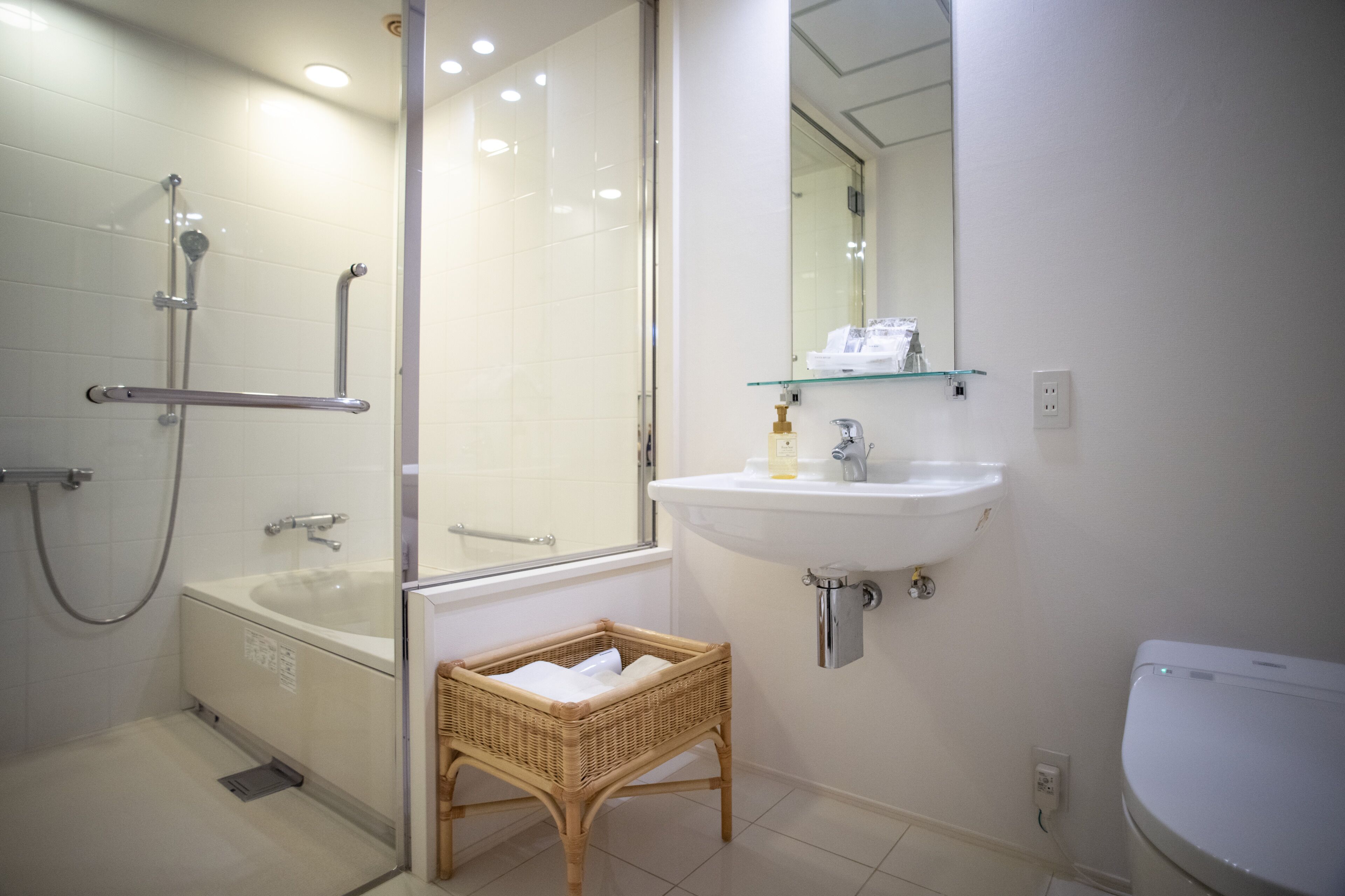 Een badkamer met een douchecabine van glas, een wit wastafelmeubel en een toilet.
