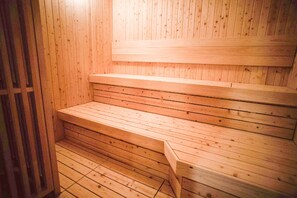 A wooden sauna with tiered seating and a wooden door. - Hotel Bestland (Tsukuba)