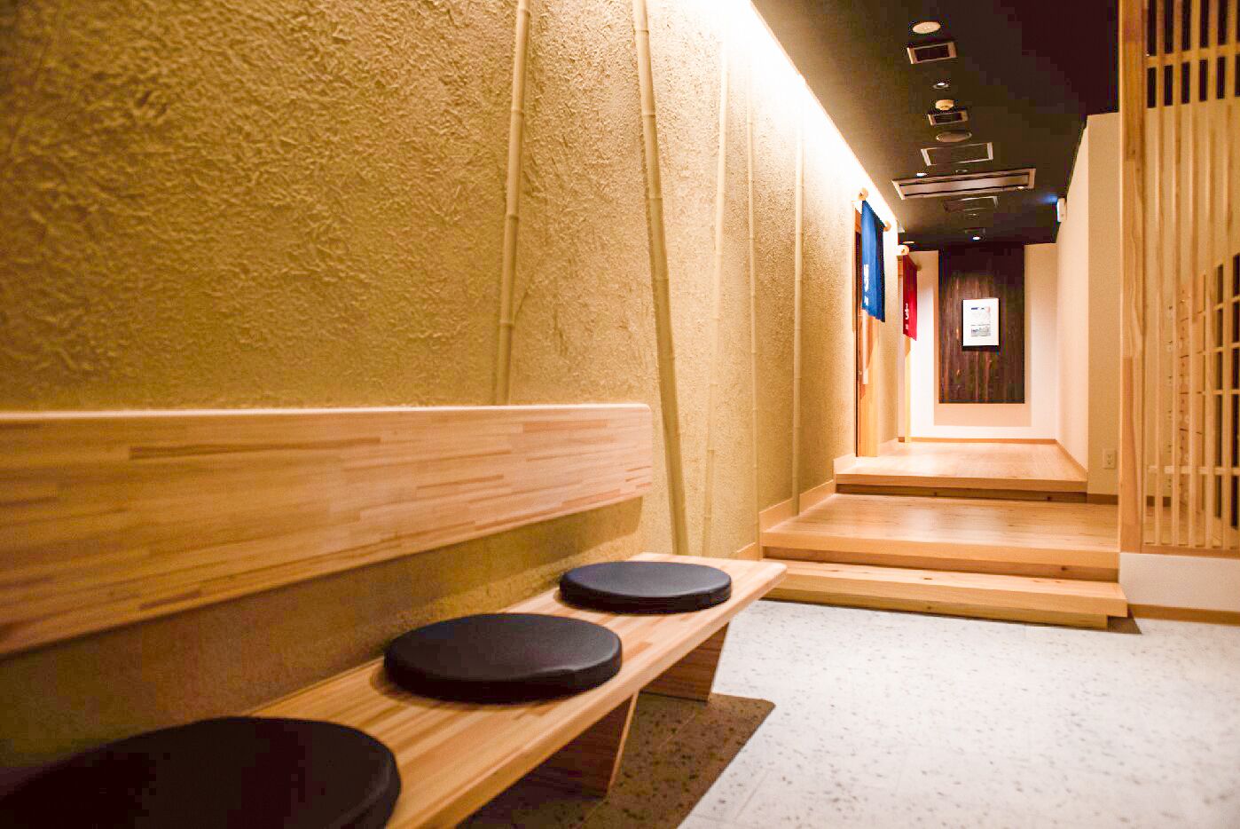 A hallway with wooden benches and a tiled floor.