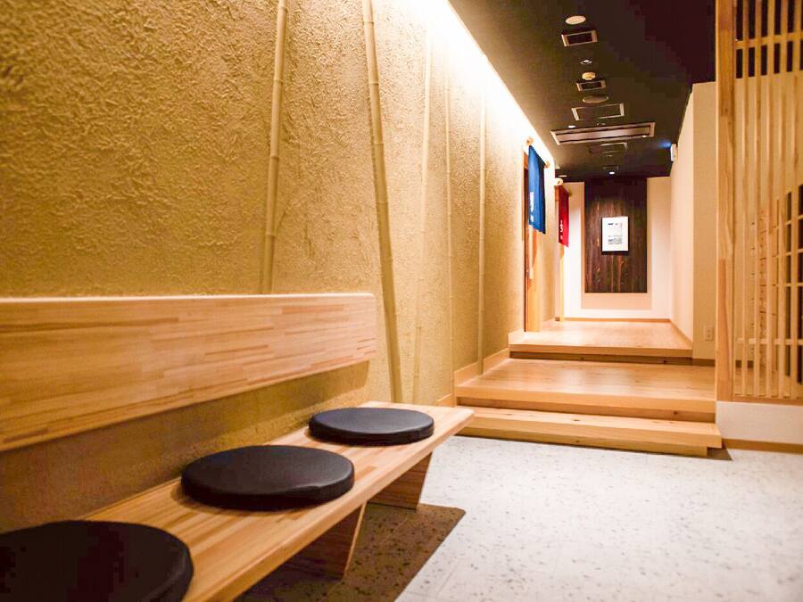 A hallway with wooden benches and a tiled floor.