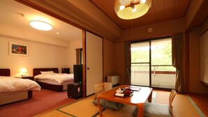 A hotel room with two beds, a dining table with chairs, a television, and a large window with curtains. - Le Vert Zao (Yamagata)