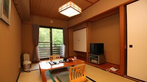 A traditional Japanese room with tatami flooring, a low table, a television, and a sliding door. - Le Vert Zao (Yamagata)