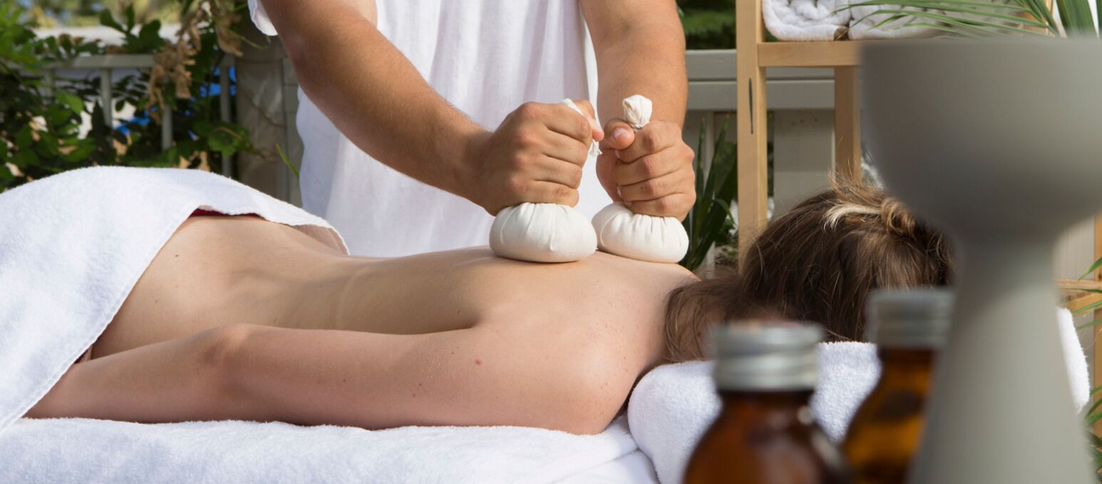 A person receiving a massage with a towel covering the body.