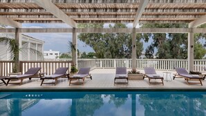 A poolside area with lounge chairs and a pergola. - Jacob NEA  (Mateh Asher)