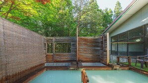 Un jacuzzi con paredes y terraza de madera.