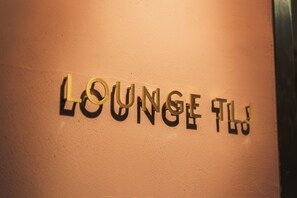 Una pared con las palabras "LOUNGE FLY" en una tipografía sans serif audaz.