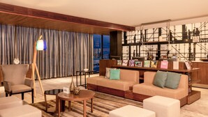 Una sala de estar moderna con un sofá, sillones, una mesa de centro y una lámpara.