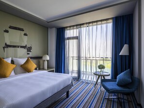 A hotel room with a bed, a chair, a small table, a lamp, and a view through the window. - Novotel Hefei Sunac (Hefei)