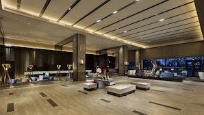 A spacious lobby with modern seating, a reception desk, and a large decorative sculpture. - Novotel Hefei Sunac (Hefei)