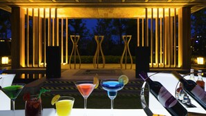 A terrace with drinks and a bottle of wine, surrounded by a wooden pergola with lights. - Novotel Hefei Sunac (Hefei)