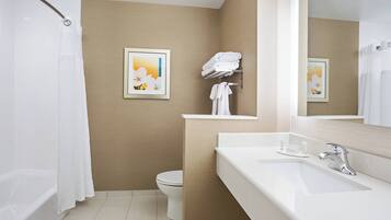 Een moderne badkamer met bad, toilet en wastafel.
