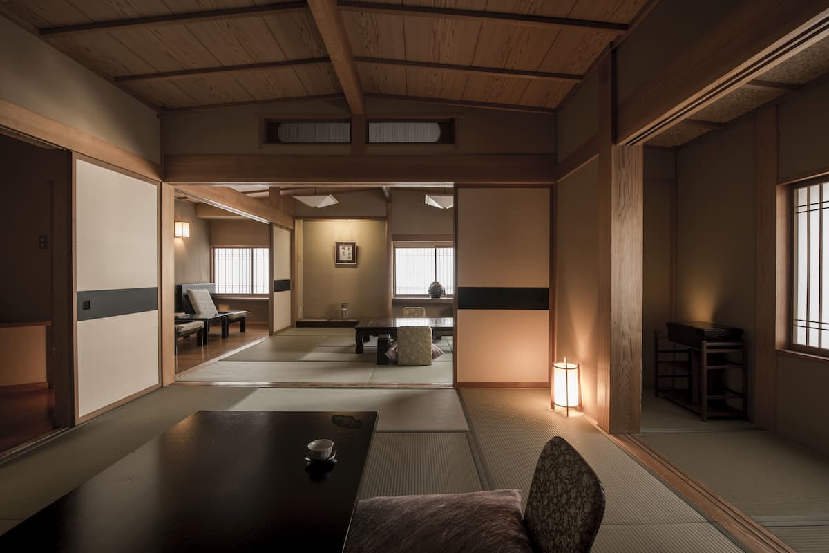 Ein traditioneller japanischer Raum mit Tatami-Böden, einem niedrigen Tisch mit einer Tasse und einem Stuhl.