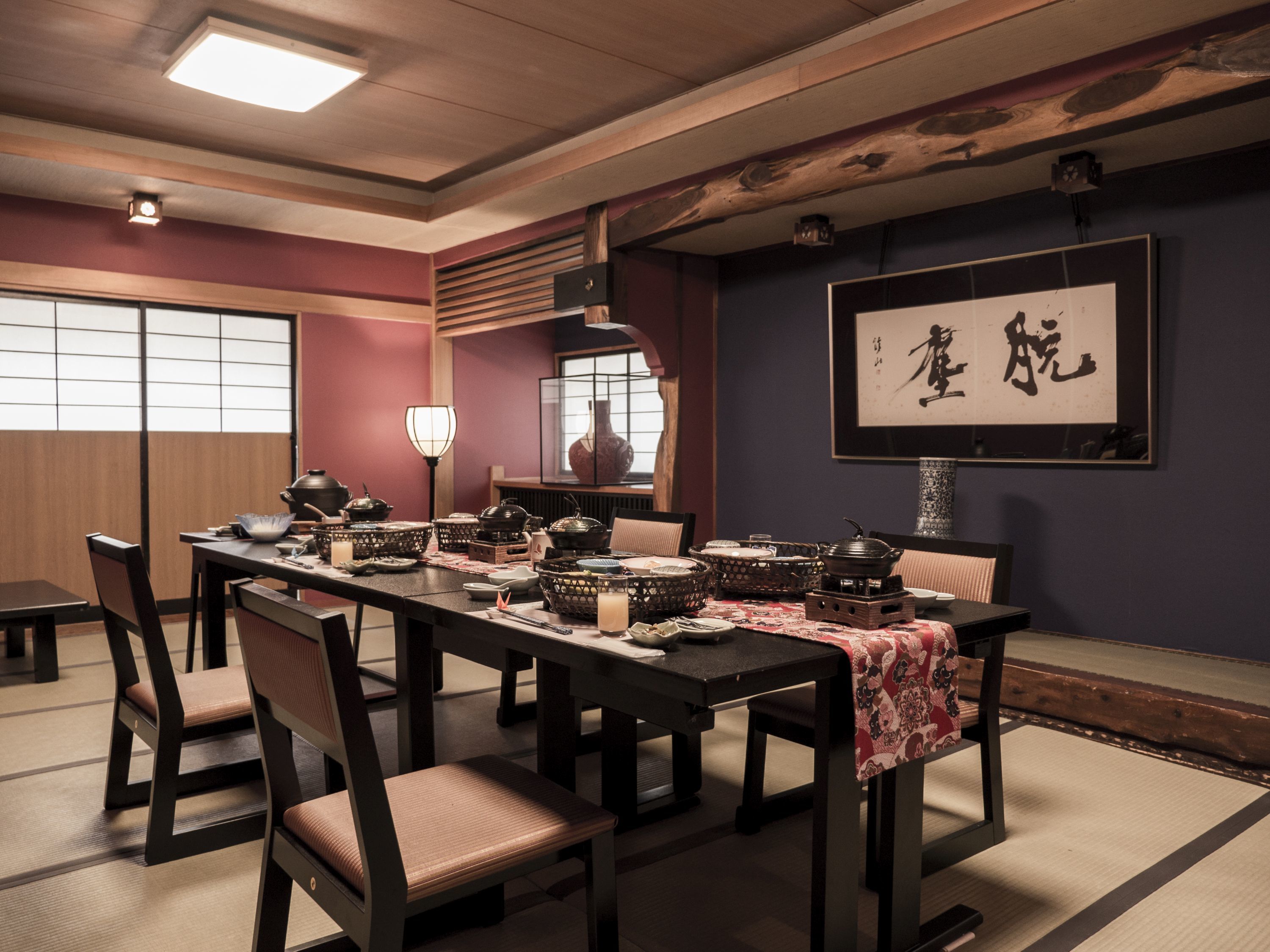 Uma sala de jantar tradicional em estilo japonês, com esteiras de tatame, mesas baixas e cadeiras de madeira.