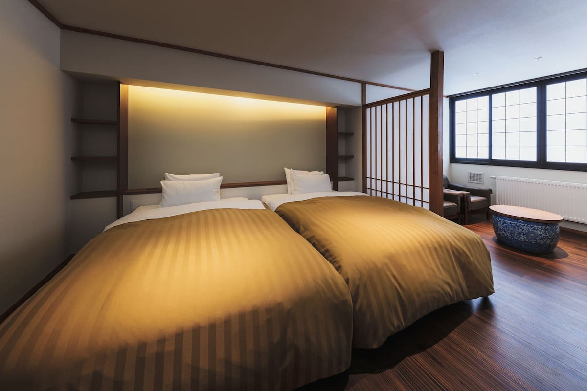 Ein Hotelzimmer mit zwei Betten, einem Schreibtisch und einem großen Fenster.
