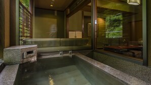 Un bagno moderno con una grande vasca, un angolo relax e un divisorio in vetro.
