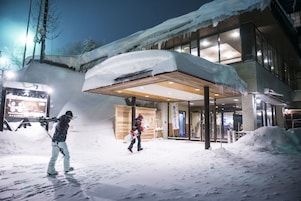 Ein Gebäude mit überdachter Eingangspartei und Schneeablagerungen darum herum.