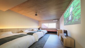 A modern hotel room with a large bed, a TV, and a projection screen displaying a nature scene. - Takamiya Hotel Jurin (Yamagata)