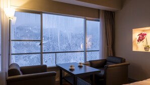 A hotel room with a large window, a table with two cups, a chair, and a bed. - Hotel Lucent Takamiya (Yamagata)