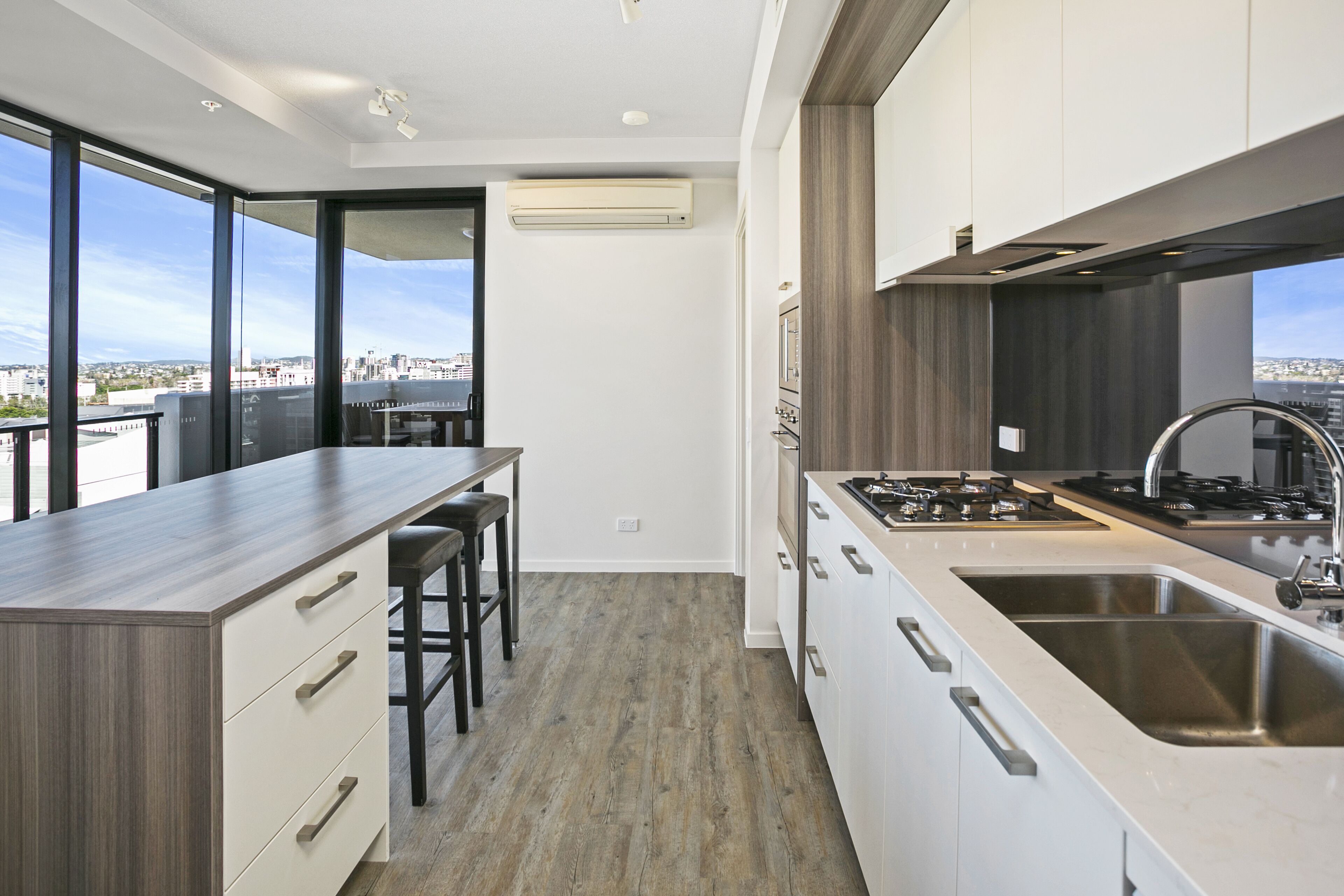 A modern kitchen with a large island, stainless steel appliances, and a view of the city.
