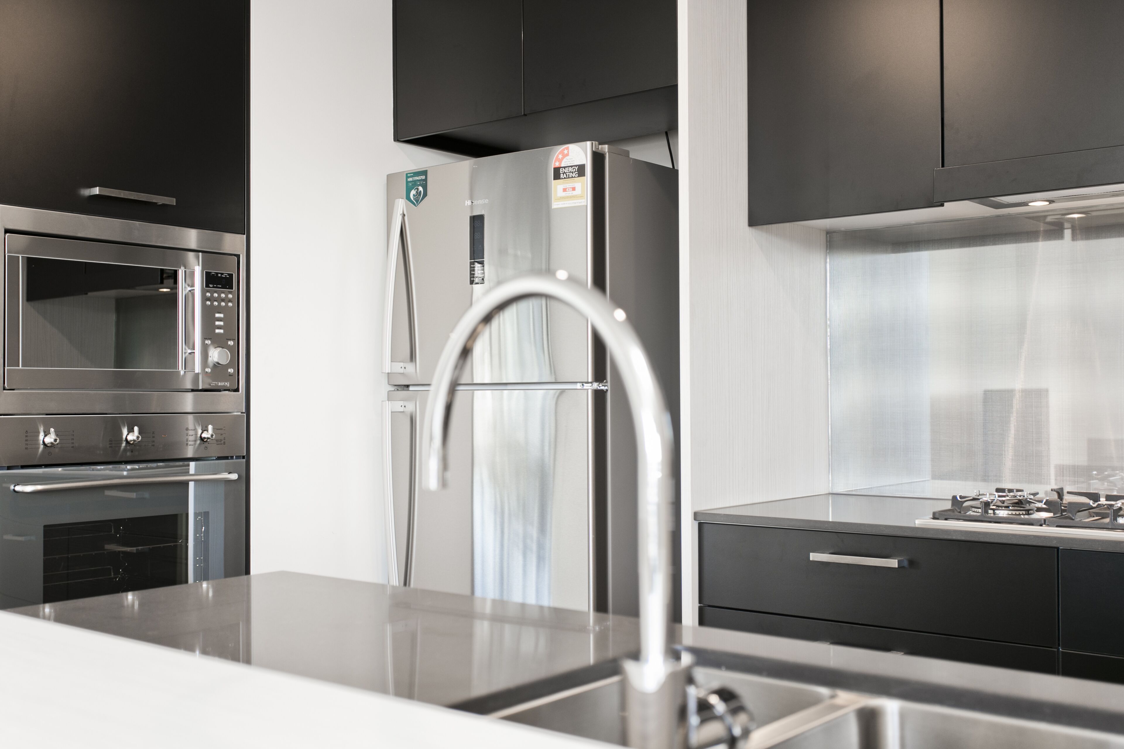 A modern kitchen with stainless steel appliances, a built-in oven, and a gas stove.