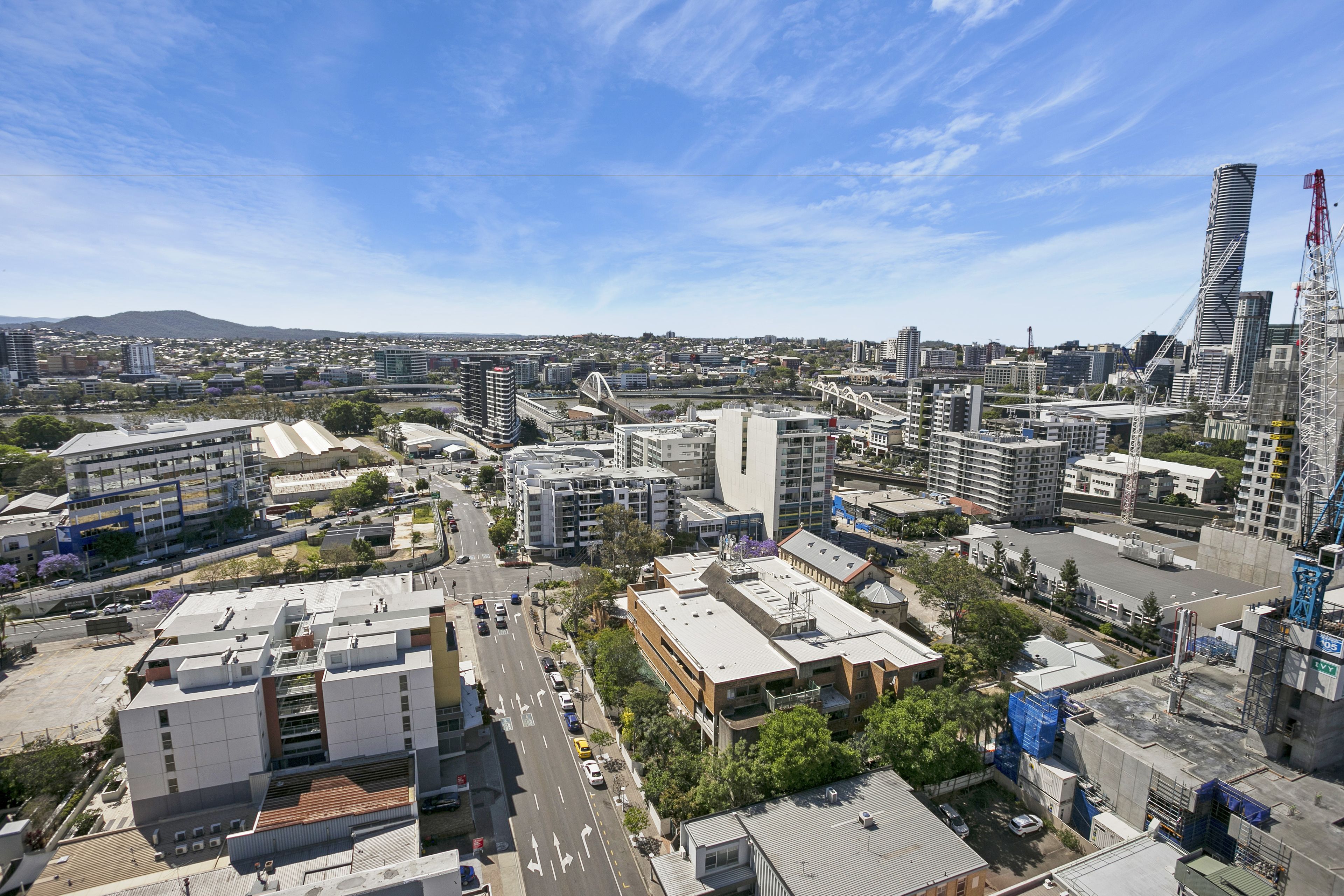 A cityscape with modern buildings, a bridge, and a construction crane.